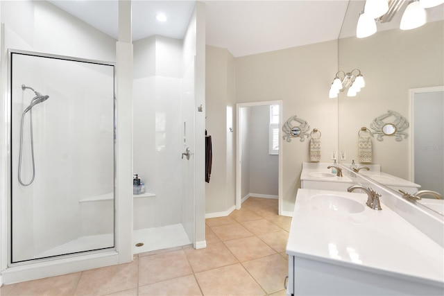 bathroom with a shower with door, vanity, and tile patterned floors