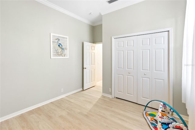 unfurnished bedroom featuring crown molding, a closet, and light hardwood / wood-style flooring