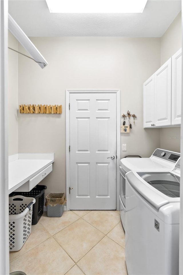 washroom featuring cabinets, separate washer and dryer, and light tile patterned floors