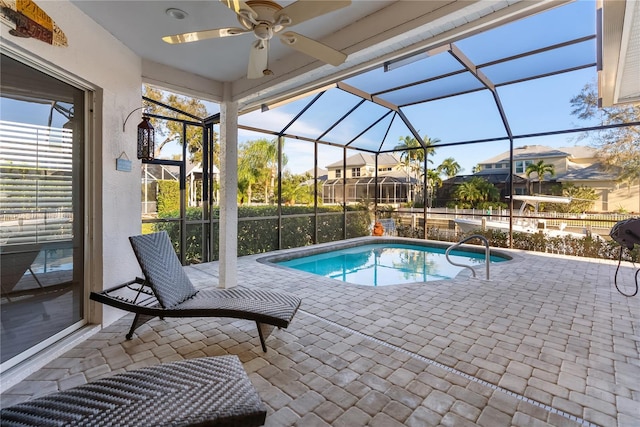 view of pool featuring glass enclosure, ceiling fan, and a patio area