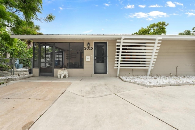 view of front of house featuring a sunroom and fence