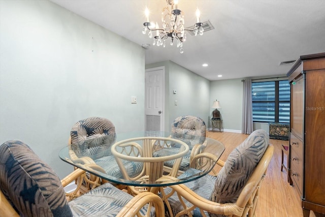 dining space with wood-type flooring and a chandelier