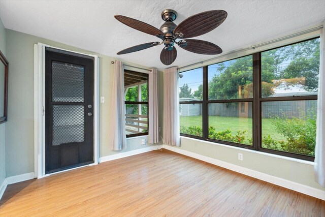 spare room with ceiling fan, light hardwood / wood-style floors, and a textured ceiling