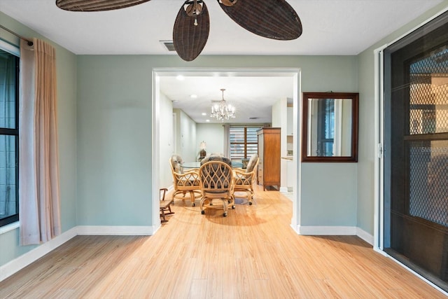 dining area with light hardwood / wood-style flooring and a chandelier