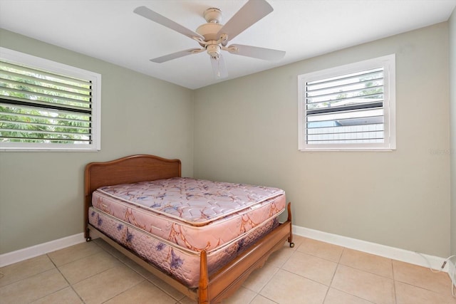 tiled bedroom with multiple windows and ceiling fan