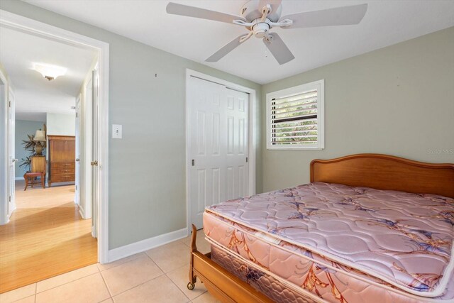 bedroom with light hardwood / wood-style floors, ceiling fan, and a closet