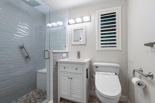 bathroom with vanity, toilet, and a shower with shower door