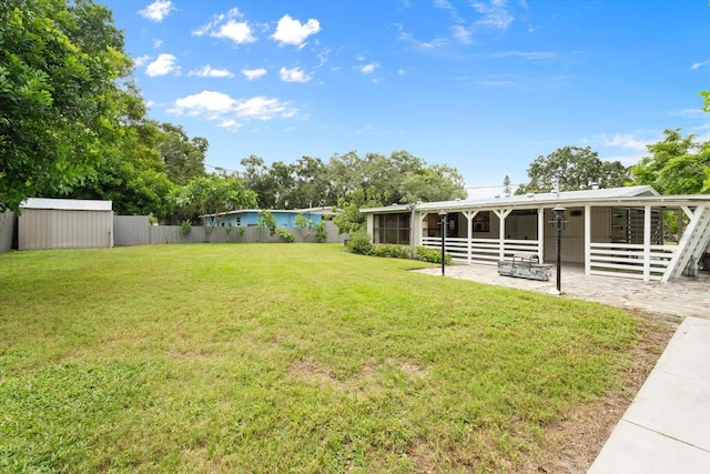 view of yard featuring a storage unit and a patio area