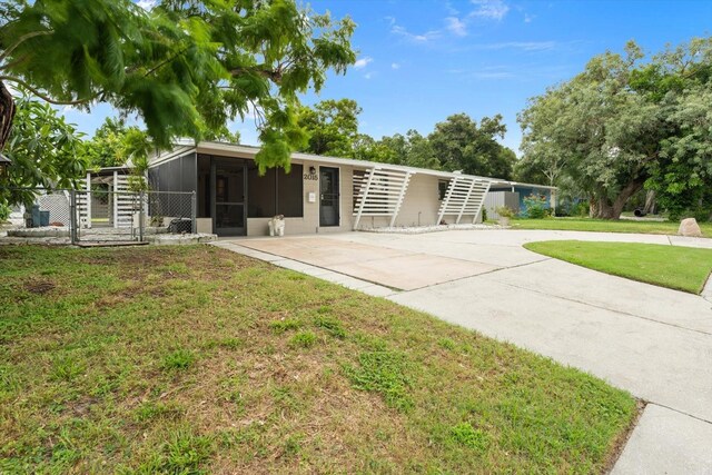 view of front of home with a front lawn and a sunroom