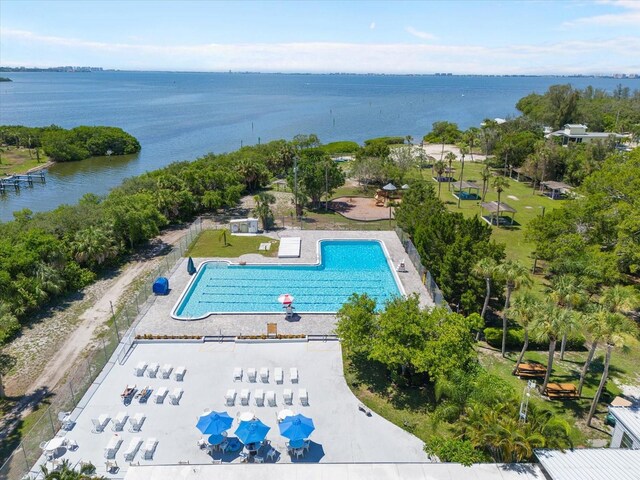 view of pool featuring a water view and a patio