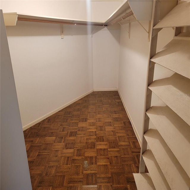 spacious closet with dark parquet floors