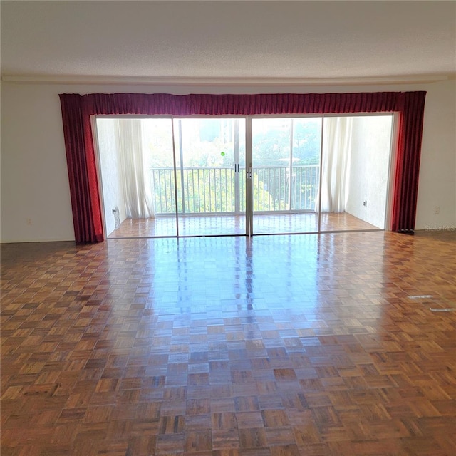 unfurnished room featuring dark parquet floors and a textured ceiling