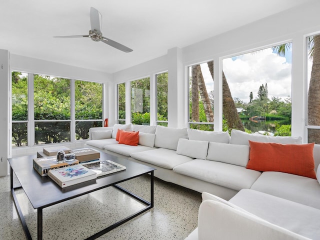 sunroom with a water view, a healthy amount of sunlight, and ceiling fan