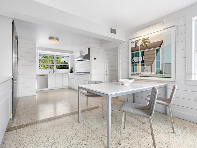 dining area featuring sink and wooden walls