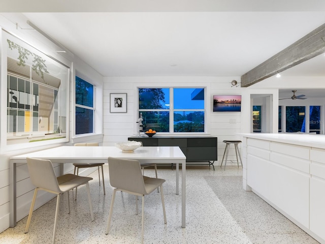 dining area featuring ceiling fan and beam ceiling