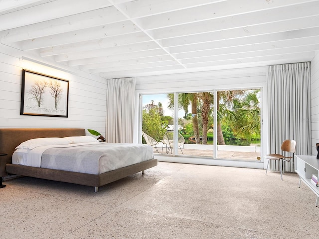 bedroom with access to outside and wooden walls