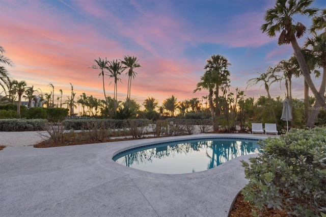 pool at dusk with a patio