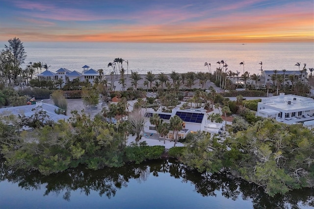 aerial view at dusk featuring a water view