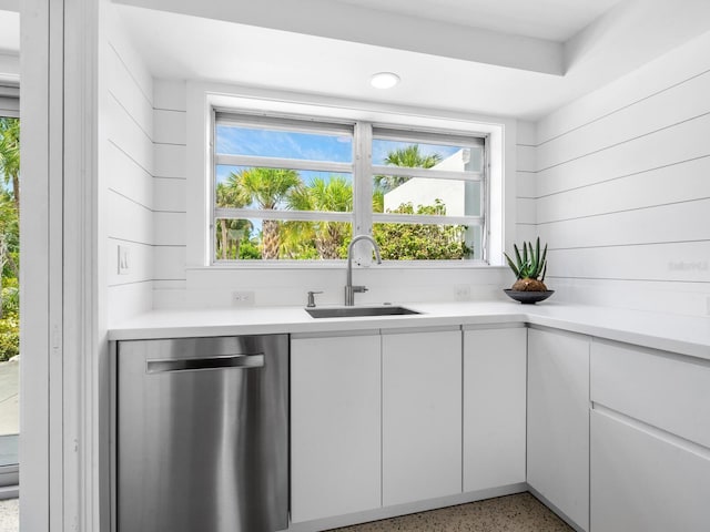 bar featuring white cabinetry, sink, wooden walls, and stainless steel dishwasher