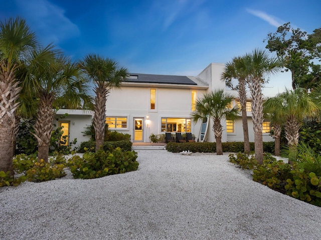 7665 Sanderling Rd, Sarasota, FL 34242 - contemporary house featuring gravel driveway, roof mounted solar panels, and stucco siding