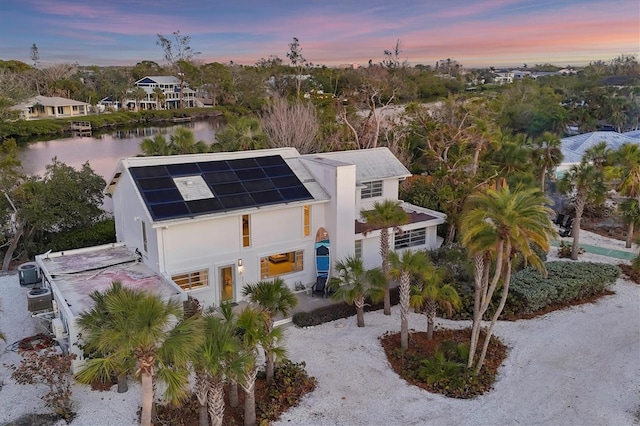 7665 Sanderling Rd, Sarasota, FL 34242 - view of front of property featuring solar panels, stucco siding, and a water view