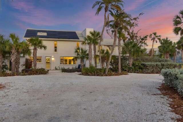 7665 Sanderling Rd, Sarasota, FL 34242 - view of front facade featuring solar panels and stucco siding