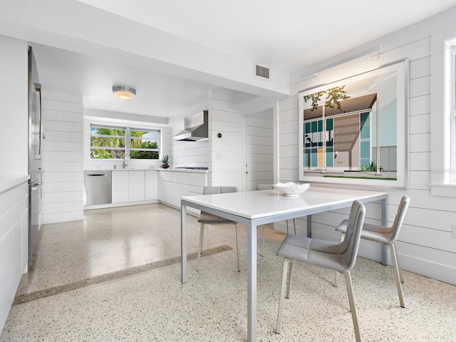 7665 Sanderling Rd, Sarasota, FL 34242 - dining room with speckle patterned floor and wood walls