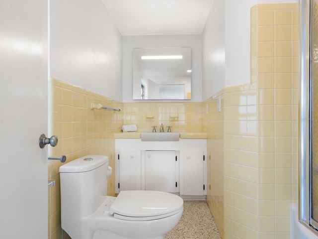 7665 Sanderling Rd, Sarasota, FL 34242 - full bathroom with tile walls, speckled floor, vanity, a wainscoted wall, and a shower