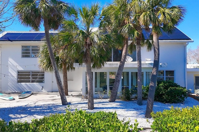 7665 Sanderling Rd, Sarasota, FL 34242 - view of front facade with stucco siding, a patio area, solar panels, and a carport