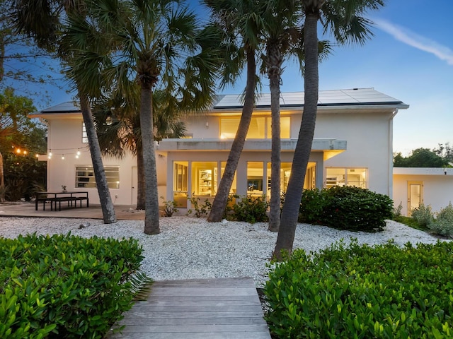 7665 Sanderling Rd, Sarasota, FL 34242 - rear view of house featuring stucco siding and roof mounted solar panels