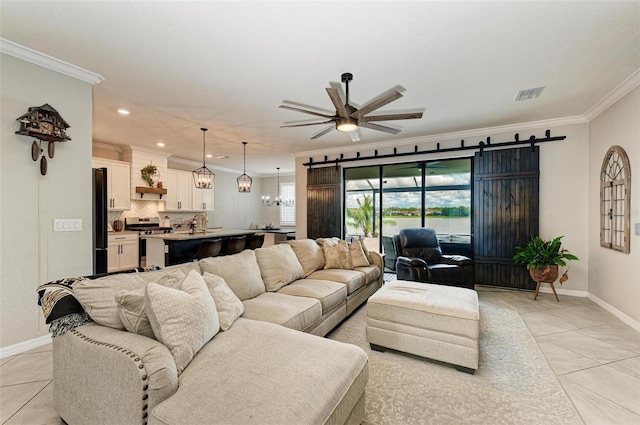 tiled living room featuring a barn door, ceiling fan, and crown molding