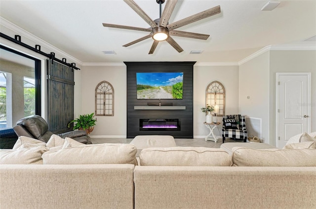 living room featuring a fireplace, crown molding, ceiling fan, and a barn door