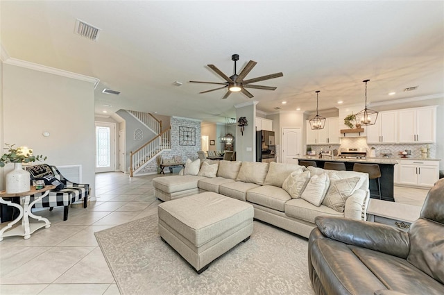 tiled living room with crown molding and ceiling fan