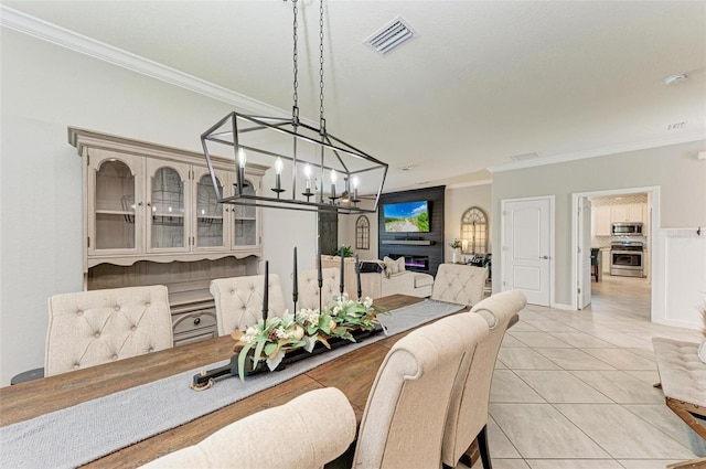 tiled dining area with crown molding and a notable chandelier