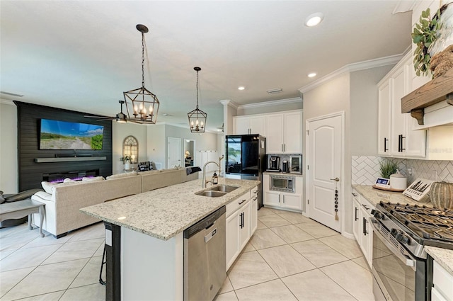 kitchen featuring stainless steel appliances, a center island with sink, white cabinetry, and sink