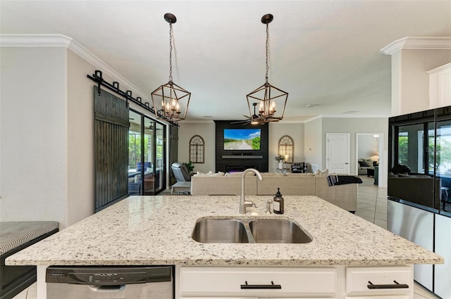 kitchen with stainless steel dishwasher, white cabinetry, light stone counters, and sink