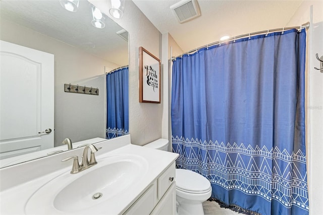 bathroom with a textured ceiling, vanity, toilet, and a shower with curtain