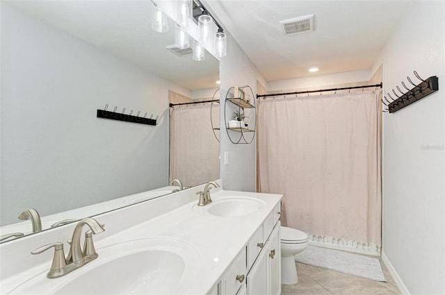 bathroom with vanity, toilet, walk in shower, and tile patterned flooring