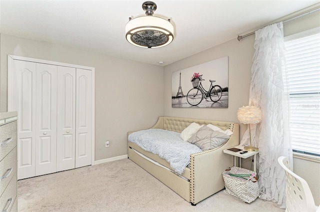 bedroom featuring a closet and light colored carpet