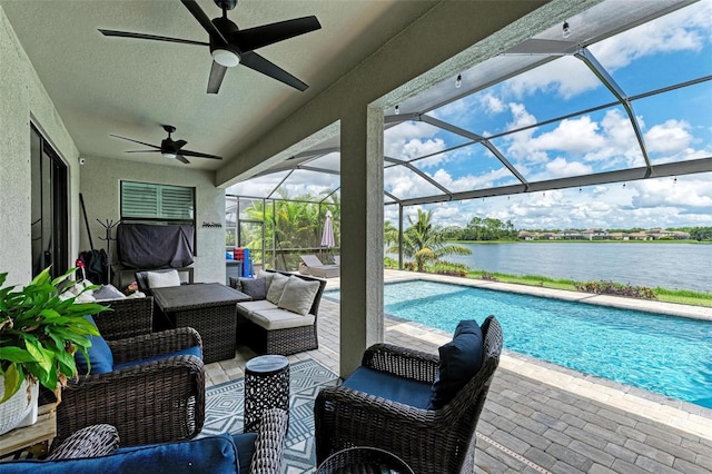 view of pool with a patio, outdoor lounge area, glass enclosure, ceiling fan, and a water view