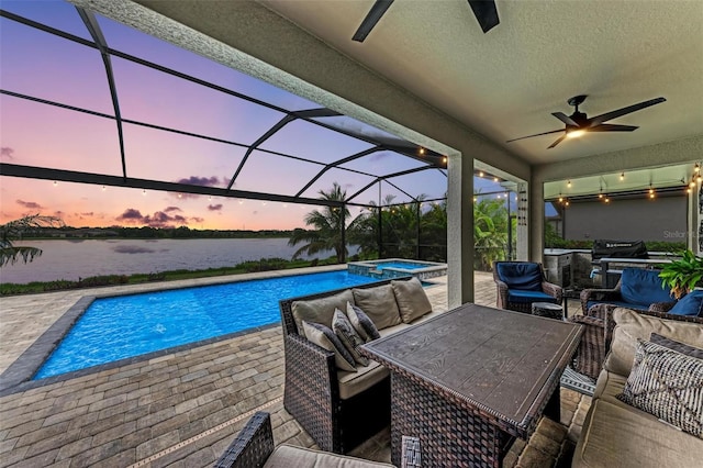 pool at dusk with a lanai, a patio, ceiling fan, an outdoor hangout area, and a water view