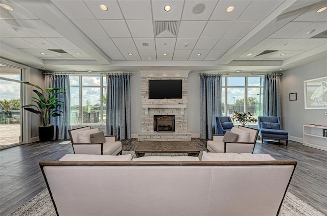 living room featuring wood-type flooring, a fireplace, and a drop ceiling