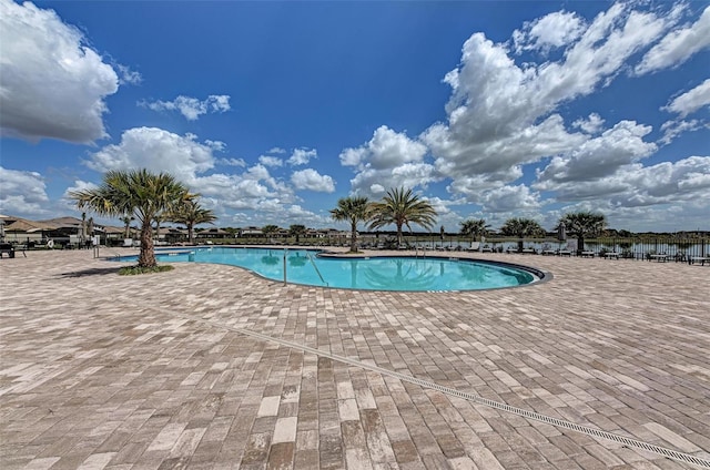 view of pool with a patio area and a water view