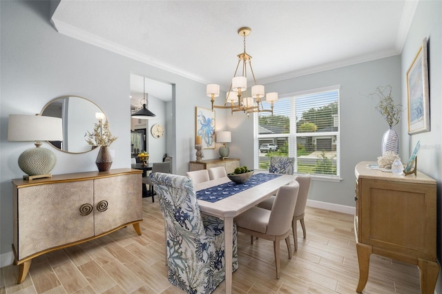 dining space featuring light hardwood / wood-style flooring, ornamental molding, and a chandelier