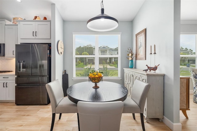 dining space with ornamental molding and a healthy amount of sunlight