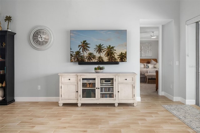 bar featuring ceiling fan and light hardwood / wood-style flooring