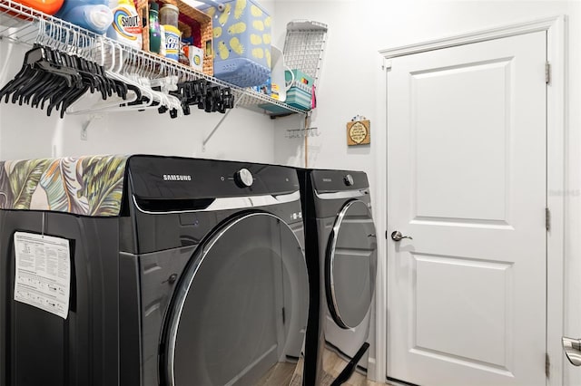 laundry room featuring hardwood / wood-style flooring and washer and clothes dryer