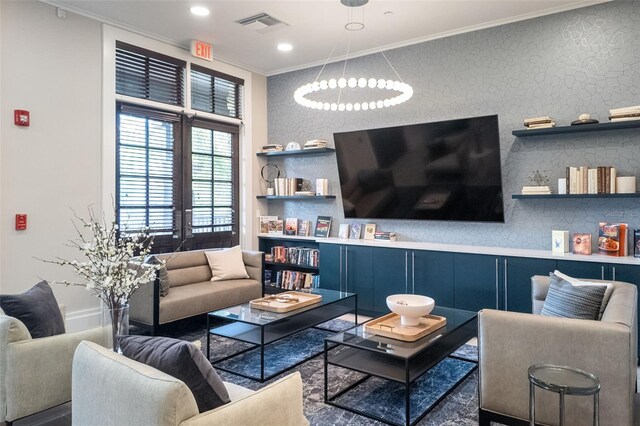 living room with an inviting chandelier and ornamental molding