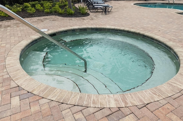 view of swimming pool featuring a patio area and an in ground hot tub