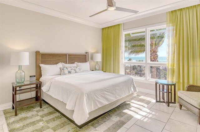 tiled bedroom featuring ceiling fan and crown molding